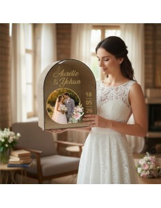 Urne de mariage personnalisée en bois et acrylique avec photo des mariés, présentée par une mariée en robe blanche